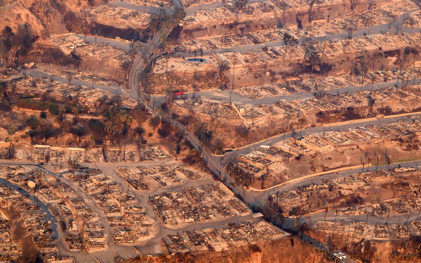 Homes burned from the Palisades fire smolder near the Pacific Palisades neighborhood of Los Angeles, California, last month. Extreme weather impacts are driving up insurance premiums